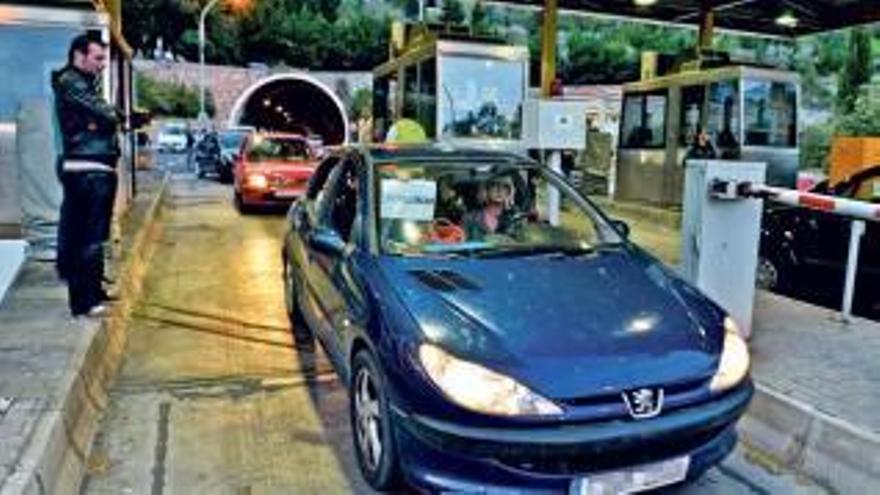 Vor dem Tunnel zeigt eine Frau in einem Auto ein Protestplakat.