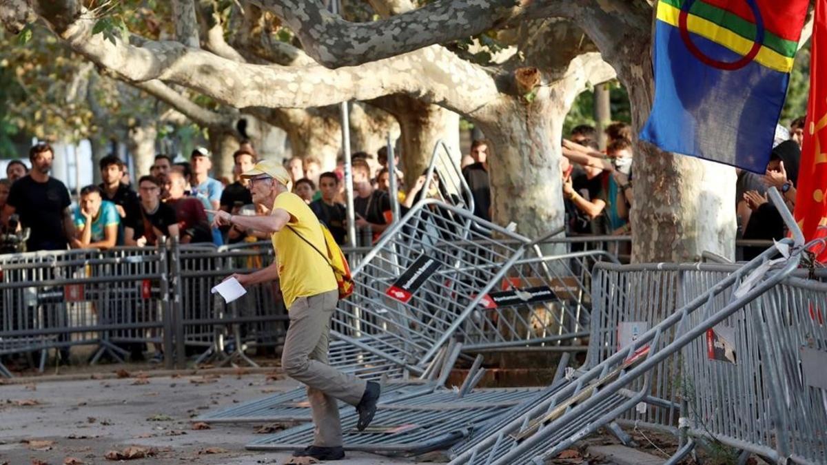 Un hombre atraviesa las vallas colocadas frente al Parlament de Catalunya