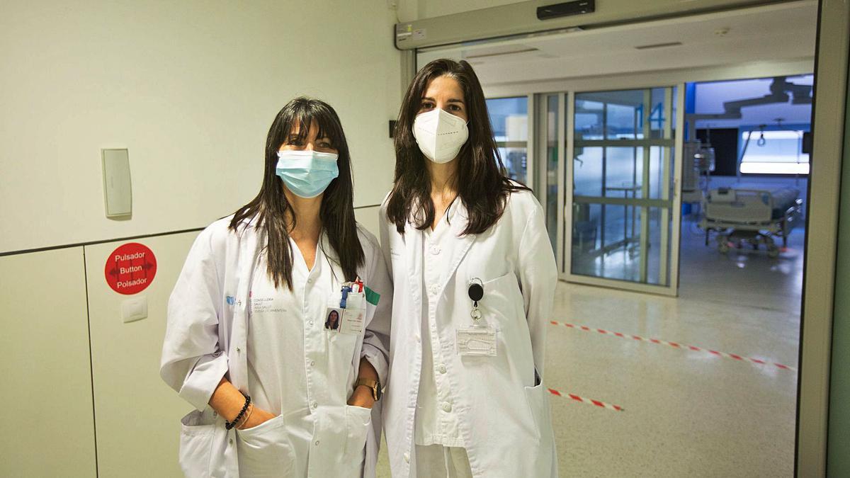 La fisioterapeuta Raquel Zafra y la médico rehabilitadora Rocío Martín, en el acceso a los boxes de de la UCI de Can Misses.