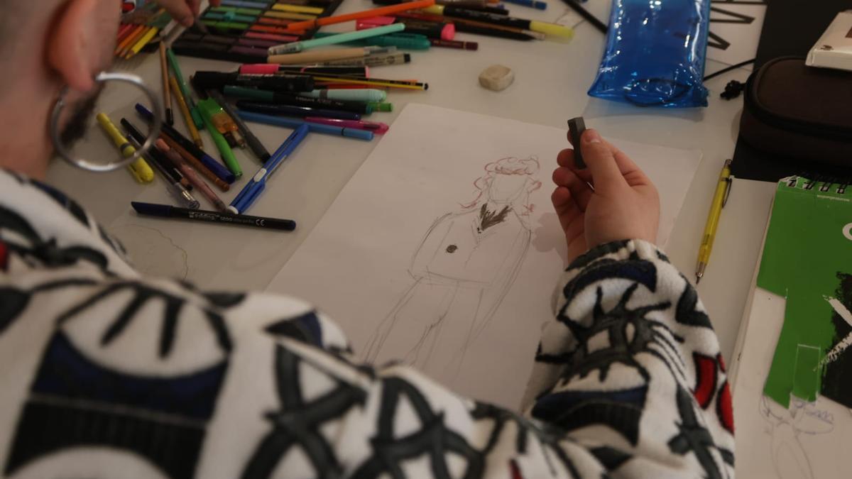 Uno de los jóvenes crea un boceto del diseño mostrado.