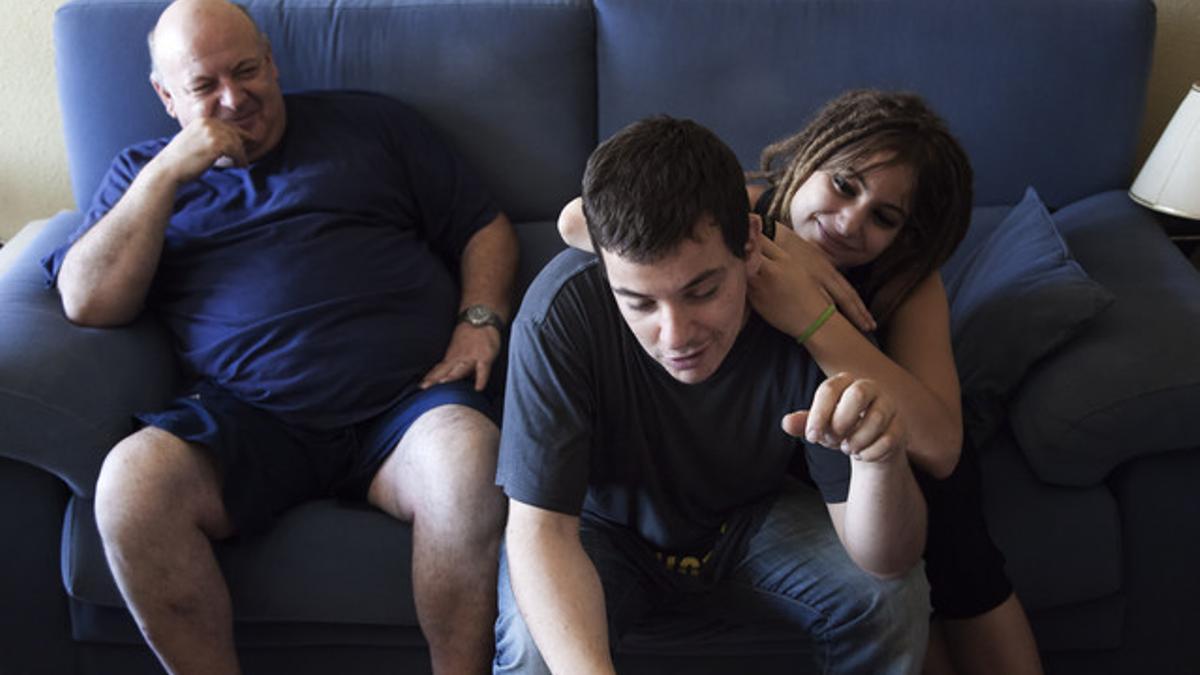 Víctor, joven con discapacidad intelectual, junto a su familia en su casa de Gandia. XAVI HERRERO