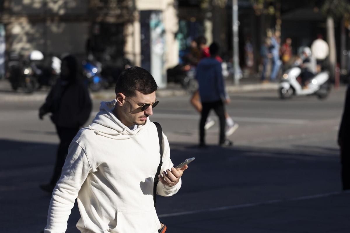 Un tercio de los peatones caminan por la calle distraídos con el móvil, según el primer Barómetro de la movilidad de los peatones en Barcelona del RACC.