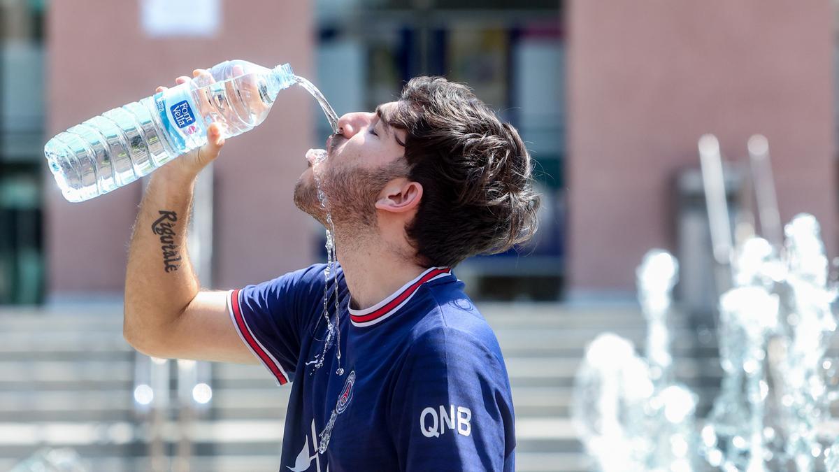 Un joven bebe agua para combatir la ola de calor