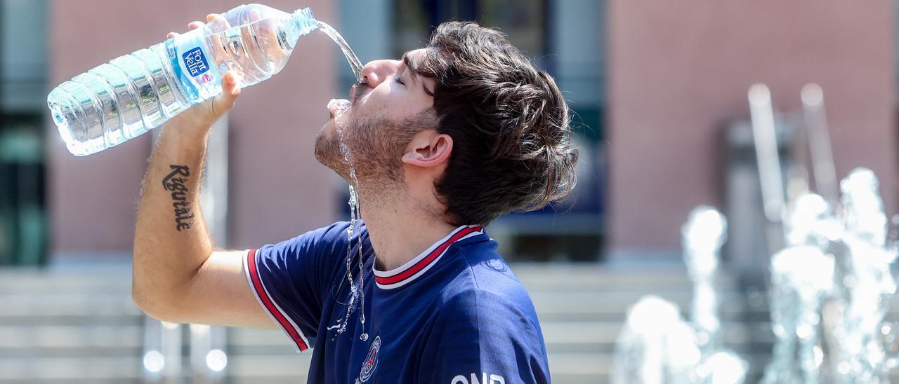 Archivo - Un joven bebe agua para combatir la segunda ola de calor del verano, a 12 de julio de 2022, en Madrid (España).