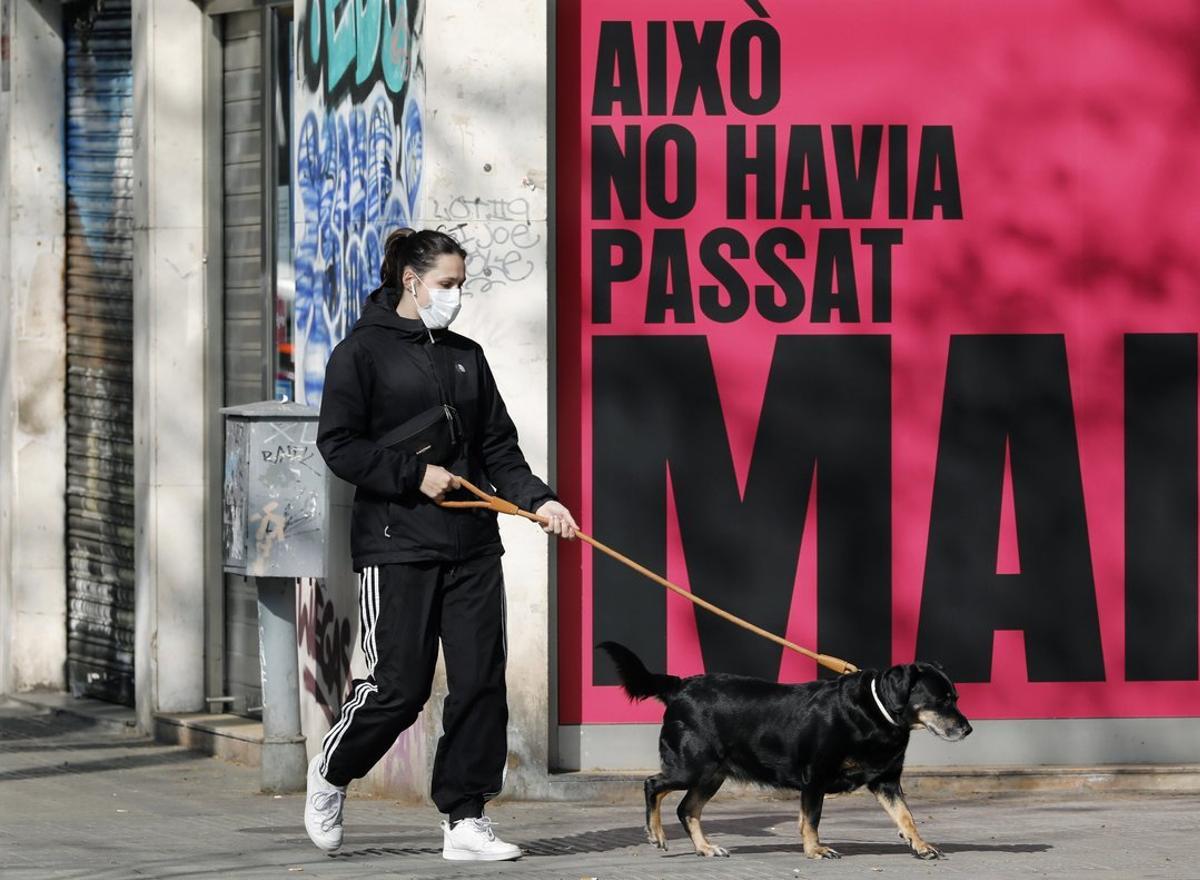 GRAFCAT3168. BARCELONA, 19/03/2020.- Una persona pasea a su perro por la Avenida del Paralelo de Barcelona, este jueves, durante la quinta jornada en estado de alarma por la pandemia de coronavirus. EFE/Andreu Dalmau