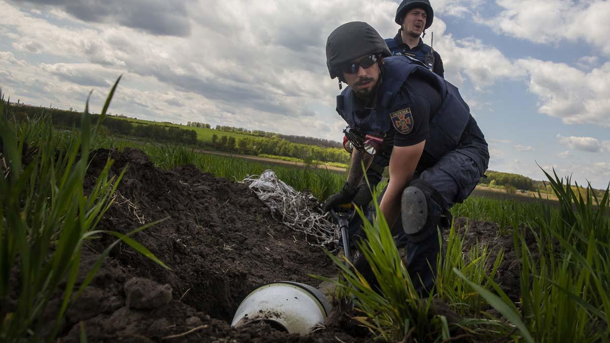 Retirada de fragmentos de una bomba de racimo en una localidad ucraniana