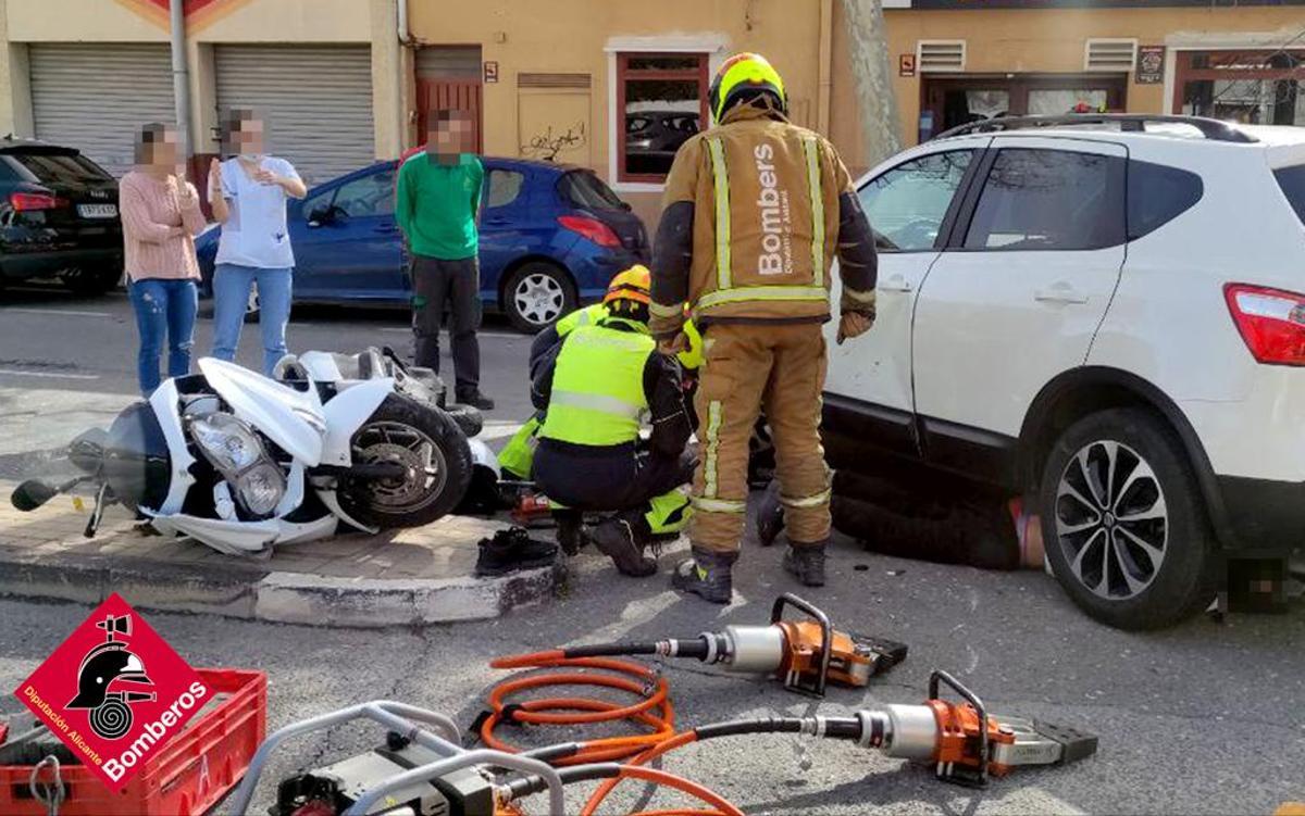 Los bomberos durante su intervención con el accidentado debajo del coche.