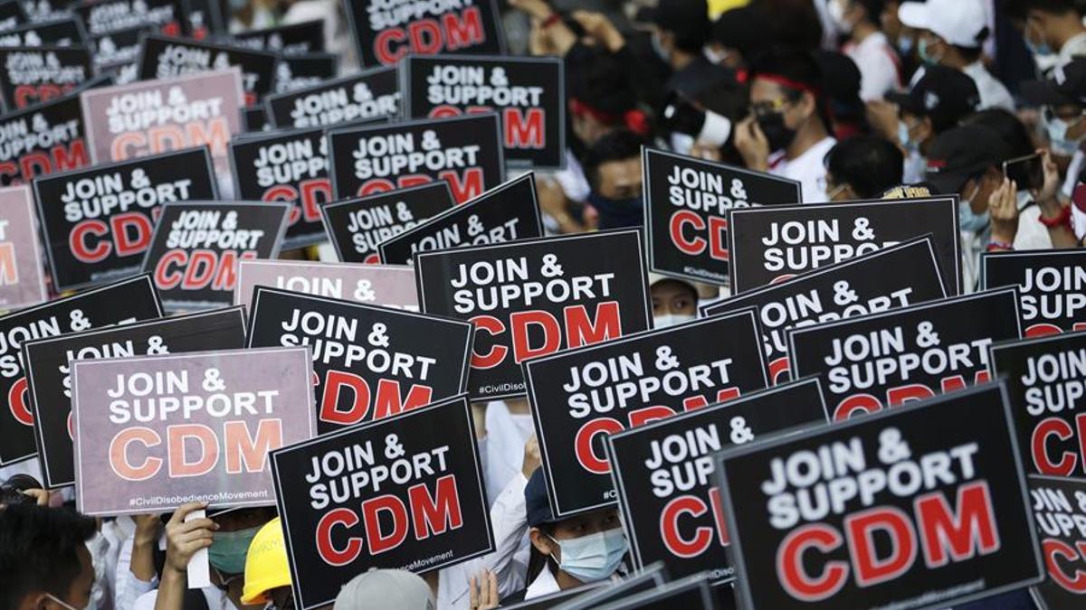 Manifestantes en Birmania muestran carteles que piden a los ciudadanos que se unan al movimiento de desobediencia civil (CDM, Civil Desobedience Movement).