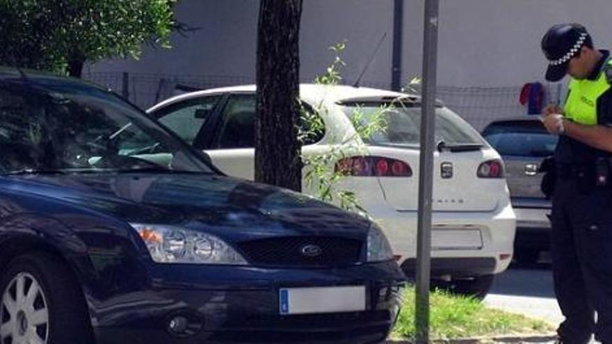 Un Policía Local imponiendo una sanción a un vehículo.