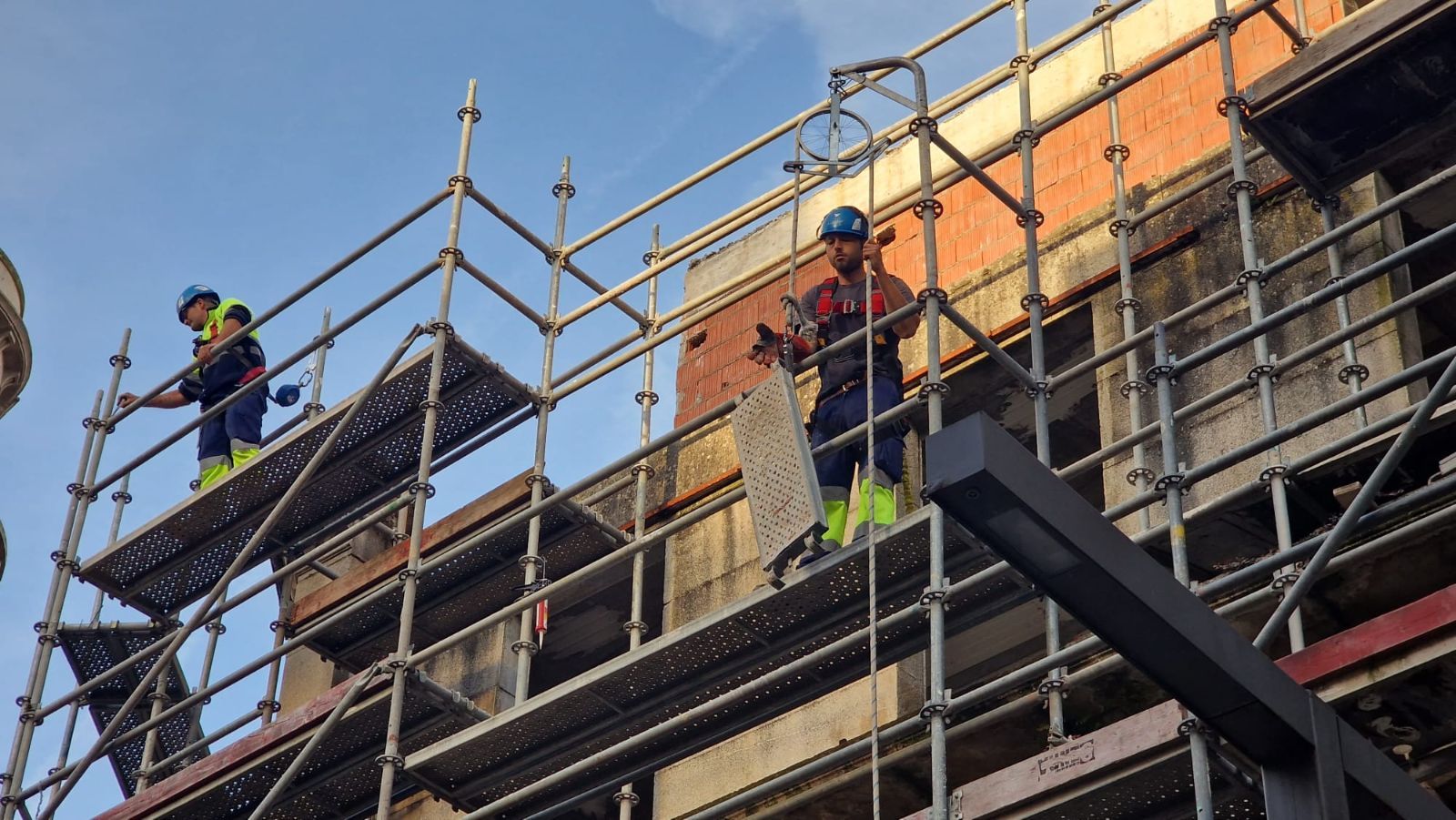 Así se desmontan los andamios en el edificio protegido del centro de Vilagarcía, cuya reconstrucción está a medias y fue paralizada por el Concello hace un año.