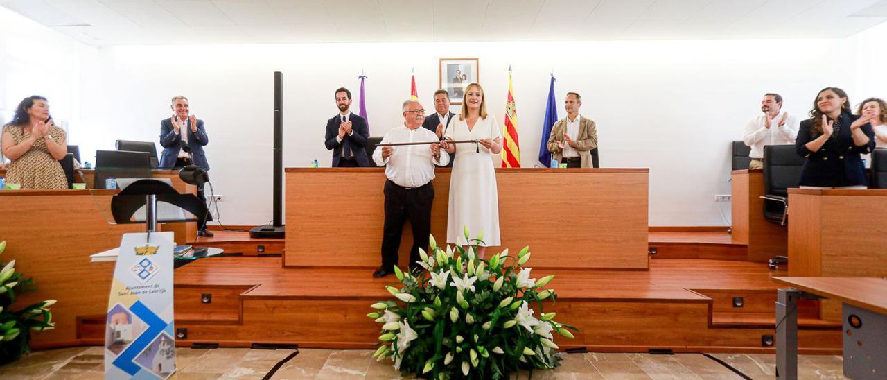 La alcaldesa de Sant Joan, Tania Marí, recoge el bastón de mando de su antecesor, Antoni Marí, en el acto de investidura. | TONI ESCOBAR