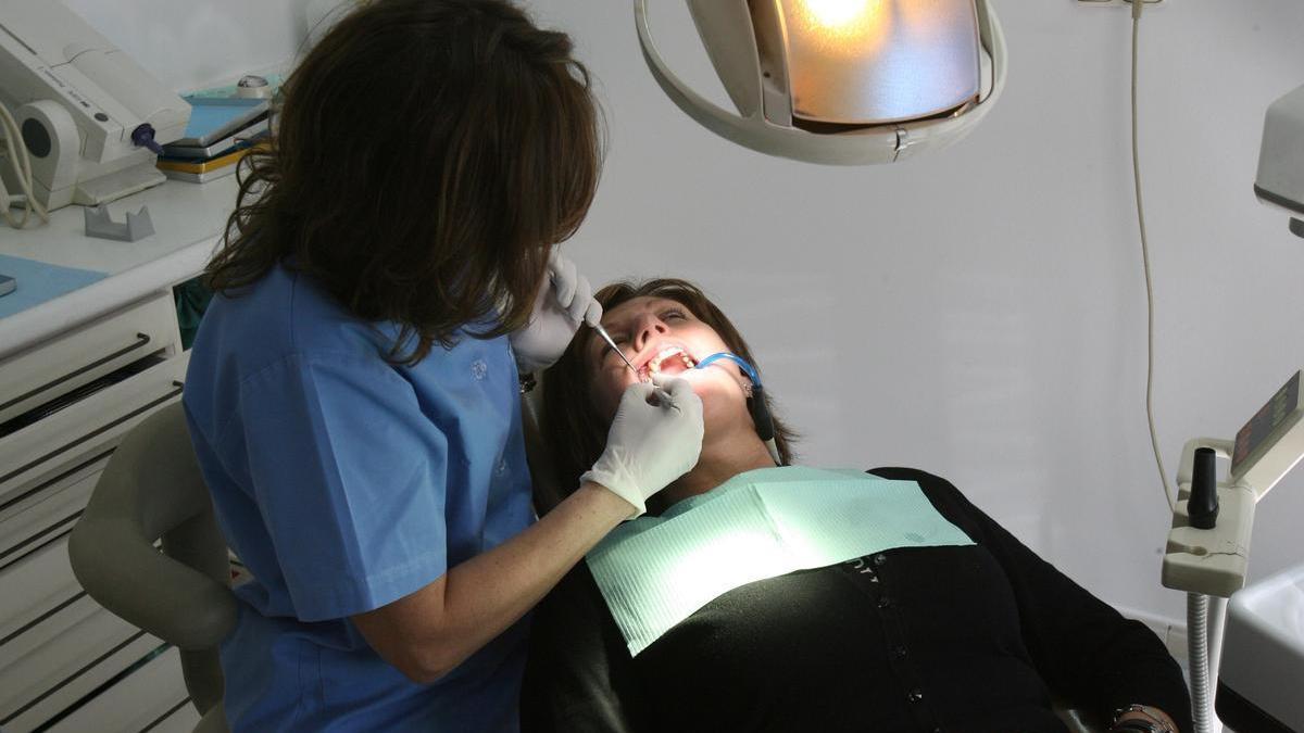 Una dentista atiende a un paciente.