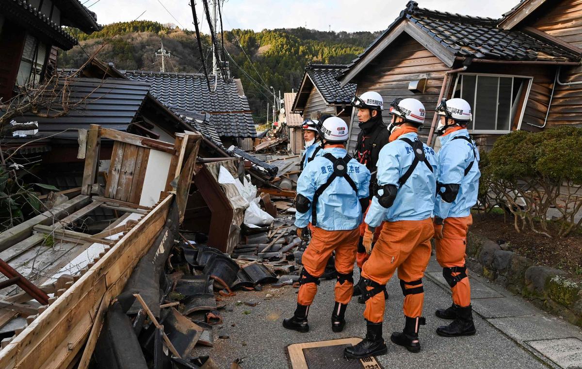 Los bomberos inspeccionan casas de madera derrumbadas en Wajima, prefectura de Ishikawa, tras el terremoto de magnitud 7,5 que ha devastado el país