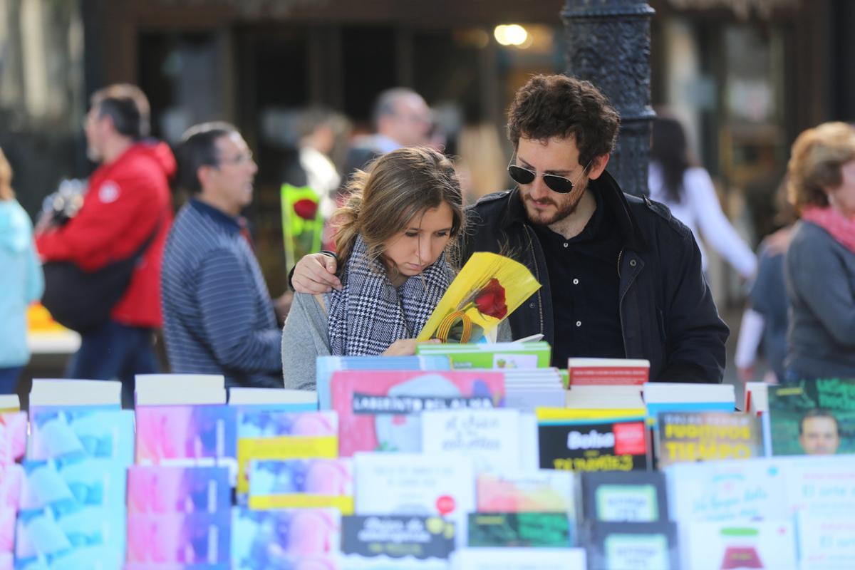 Una pareja ojea libros en una parada de plaza de Catalunya.