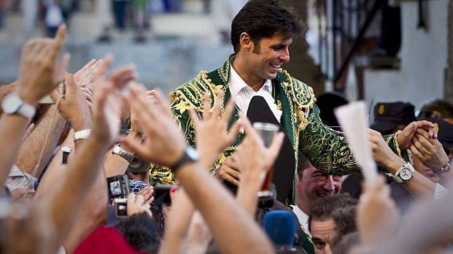 El diestro a la salida de la plaza de toros rodeado de la multitud felicitándole.