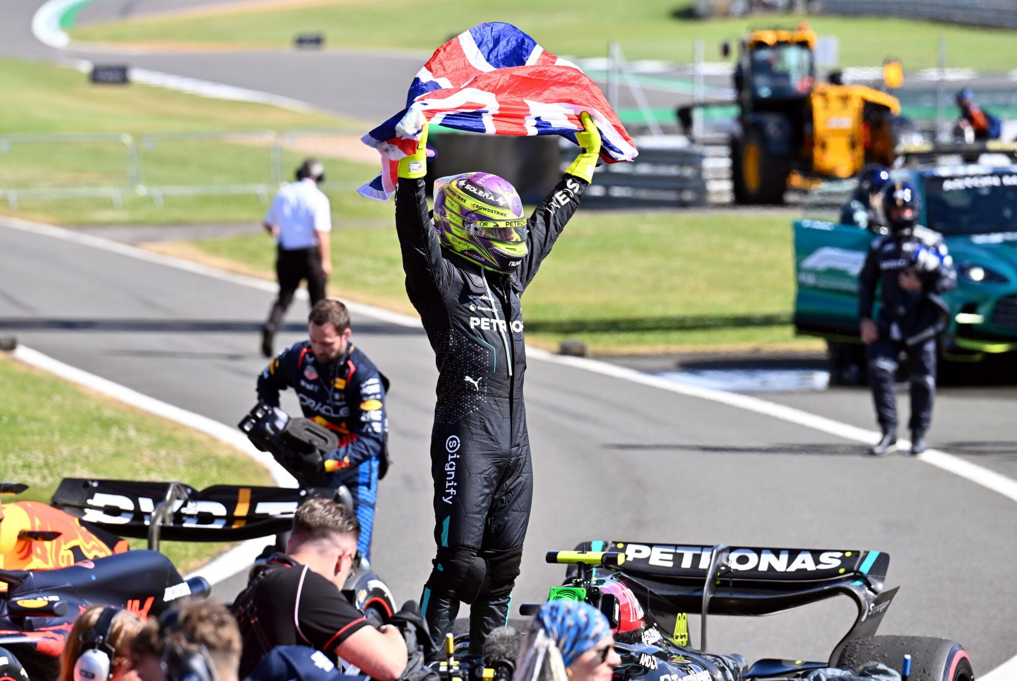 Lewis Hamilton waves the British flag after his victory in 2025