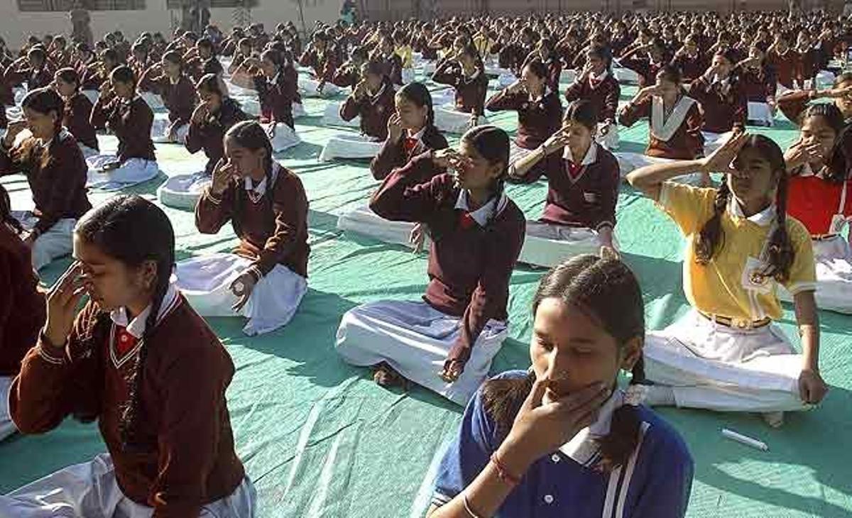 Diverses estudiants índies realitzen exercicis de ioga mentre participen en el programa Surya Namaskar, organitzat amb motiu de l’aniversari del naixement de Swami Vivekananda, a Bhopal (Índia).