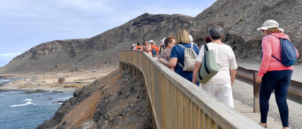 Un grupo de mayores de paseo por la playa de El Confital, en la capital grancanaria.