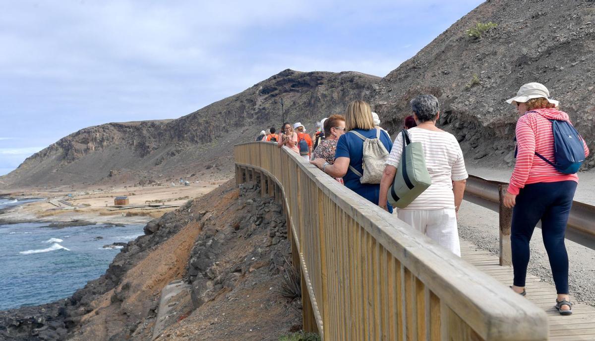 Un grupo de mayores de paseo por la playa de El Confital, en la capital grancanaria. | | ANDRÉS CRUZ