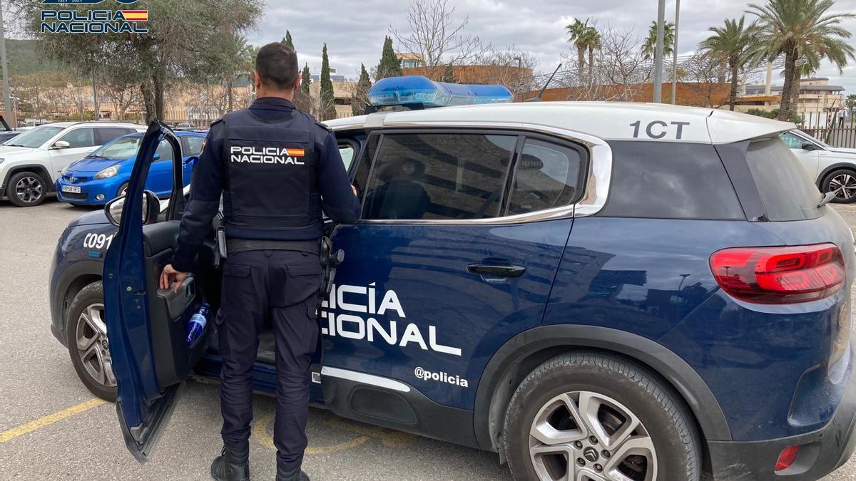 Un agente del Cuerpo Nacional de Policía de Ibiza junto a un vehículo en la comisaría