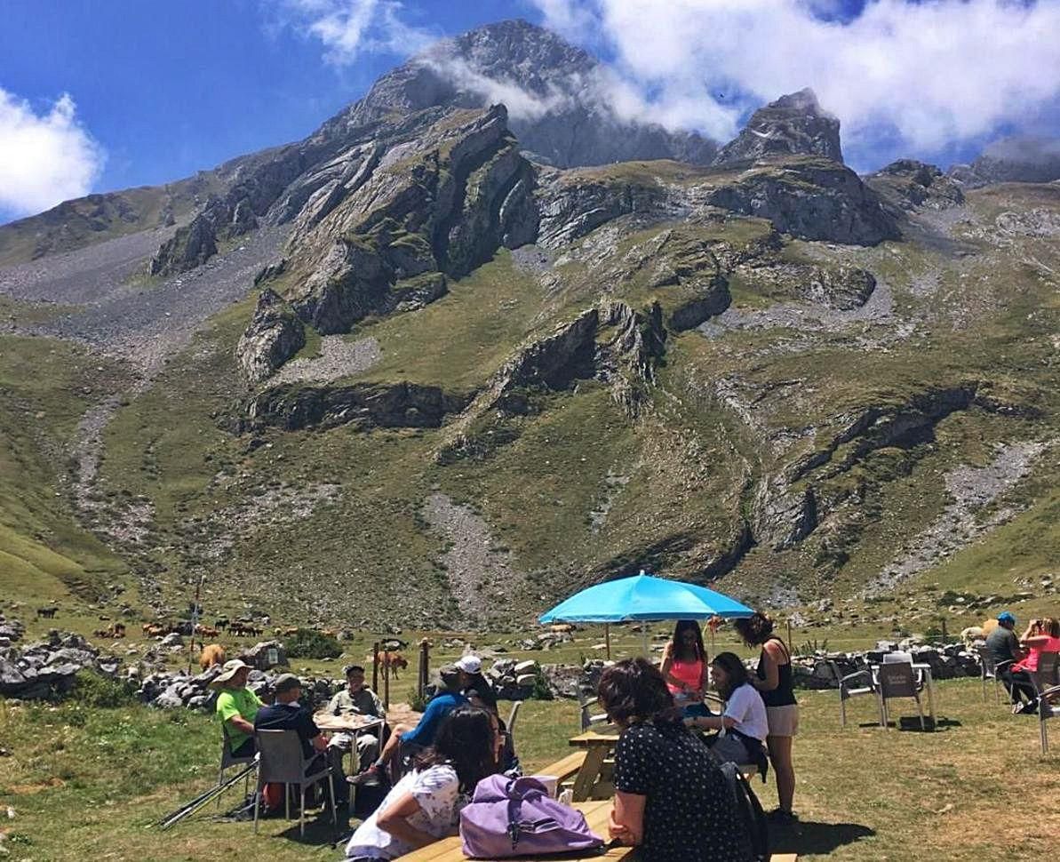 Senderistas, en un alto en la vega del Meicín; al fondo, Peña Ubiña.