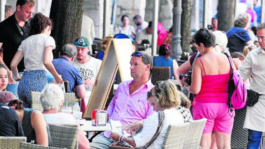 Turistes passejant per la Rambla gironina i omplint terrasses i restaurants · Marc Martí