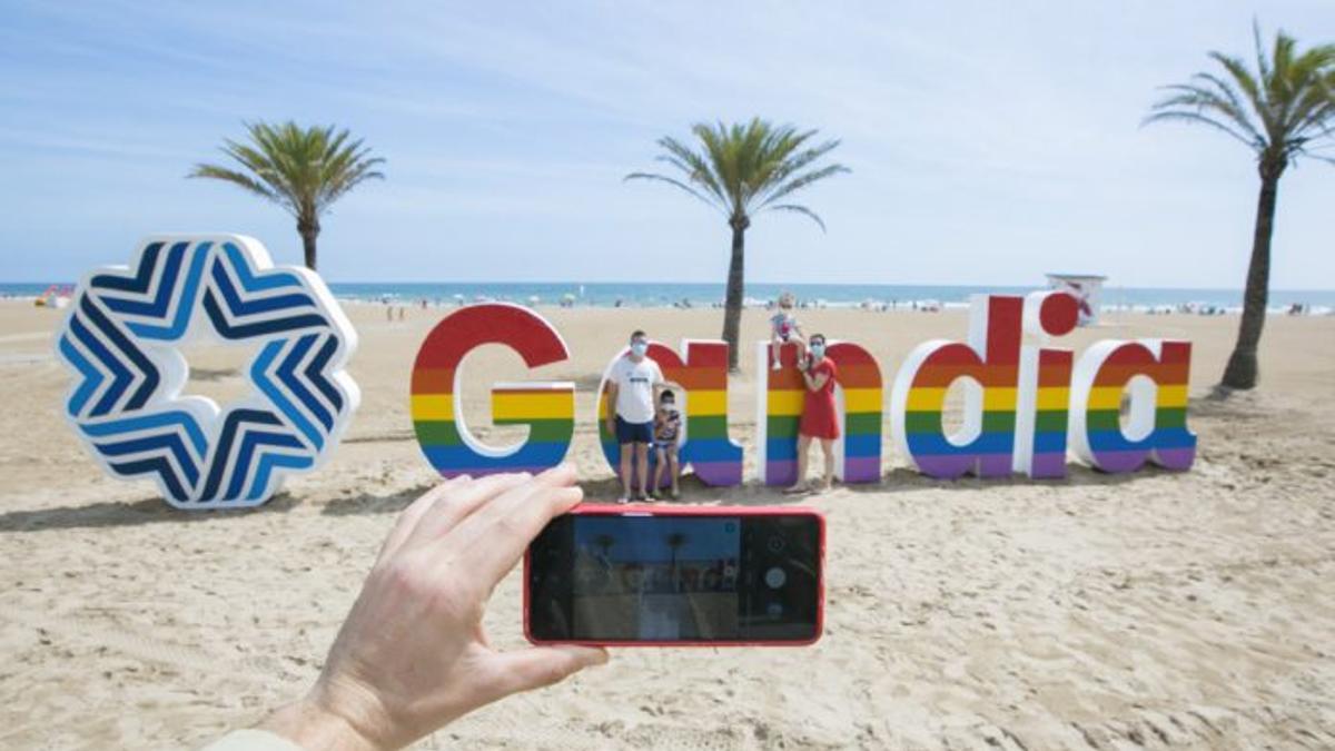El cartel de la playa de Gandia pintado con la bandera arco iris