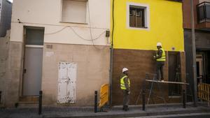 Albañiles dan los últimos retoques en las obras de rehabilitación del 120 de la calle de Pirineus de Santa Coloma de Gramenet.