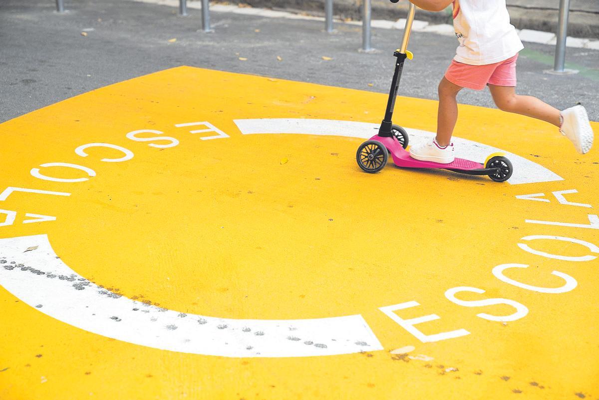 Niña en patinete sobre una zona señalizada