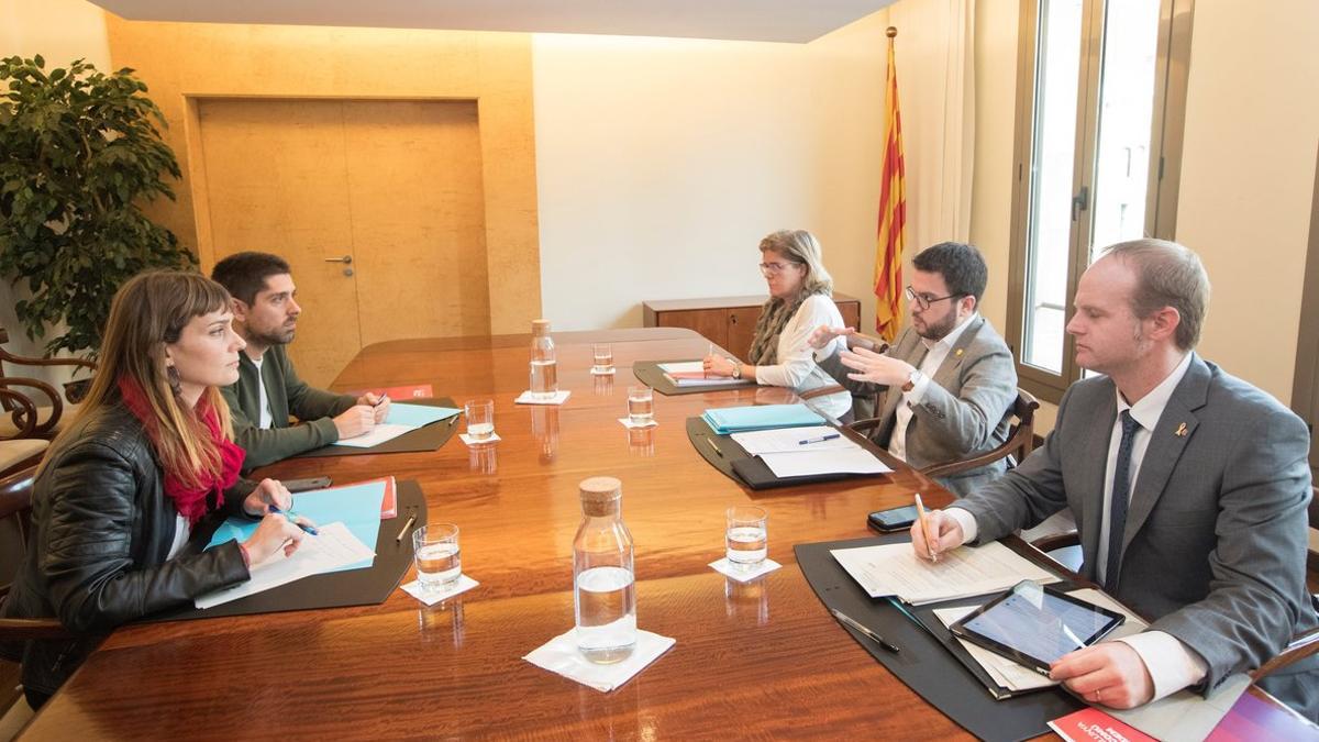 Los 'comuns' Jessica Albiach y David Cid (izquierda) frente a Pere Aragonès, Albert Castellanos y Meritxell Massó, negocian los presupuestos, en una imagen del 2018.