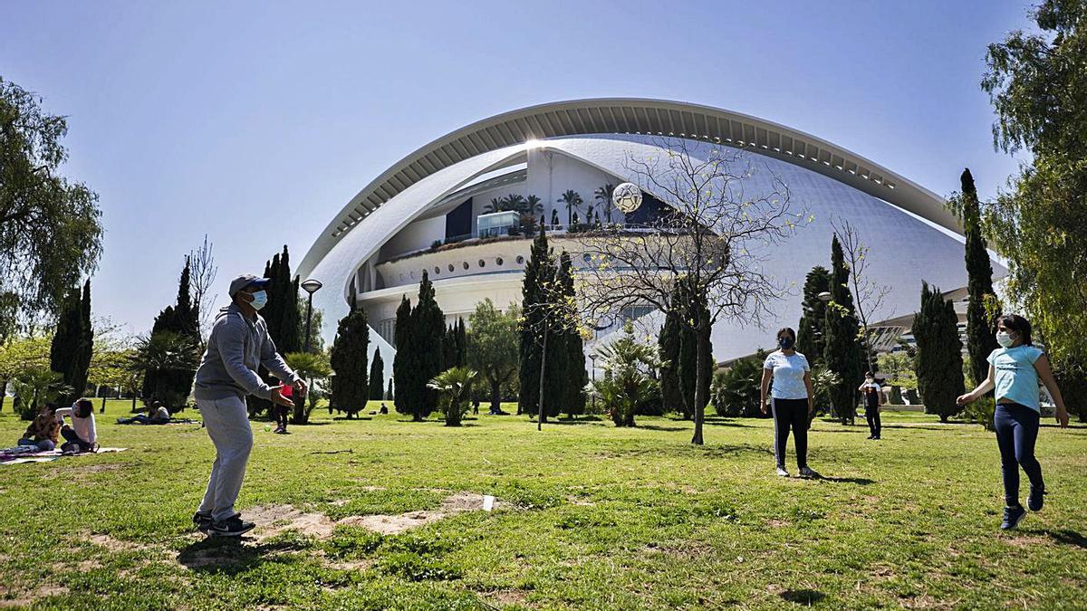 Varias personas en el césped del parque del antiguo cauce del Turia, en València