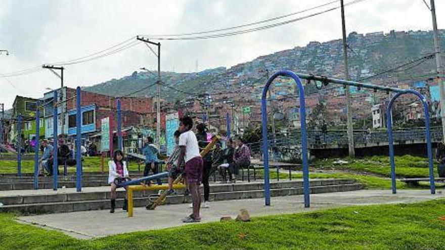 Unos niños juegan en el parque San Rafael, con las barriadas informales encaramadas a las lomas de Ciudad Bolívar como telón de fondo