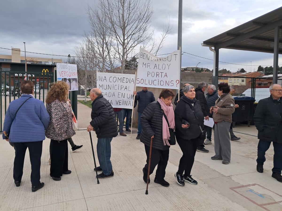 Veïns que van assistir a la trobada amb l'alcalde amb pancartes