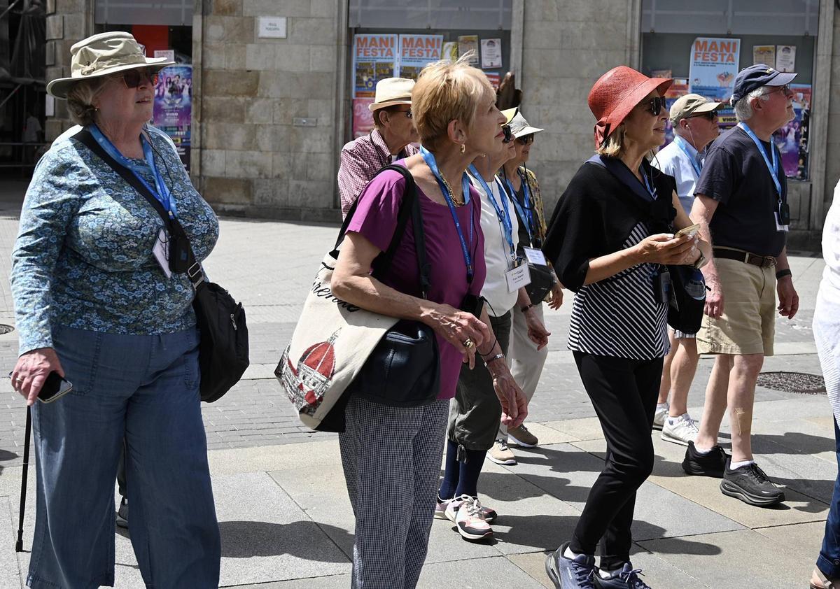 Un grupo de turistas se protege del sol con gorros en el centro de Pontevedra.