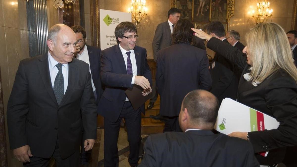 Puigdemont saluda a los asistentes a una jornada junto a Josep Bombardó, presidente de la Fundació per la Indústria en Sabadell.