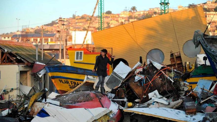 Una mujer recoge enseres de su casa destruida en la ciudad chilena de Coquimbo.