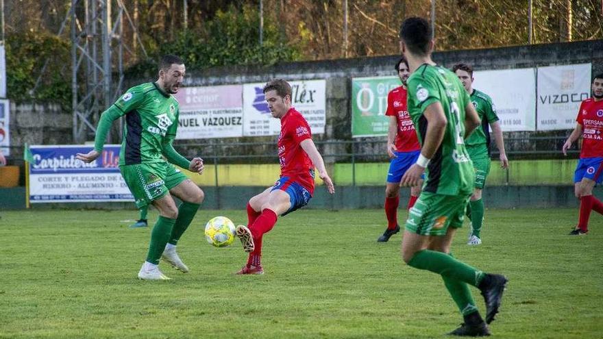 Hugo García disputa la pelota con un rival, el pasado sábado durante el derbi en Espiñedo frente al Arenteiro. // Carlos Peteiro