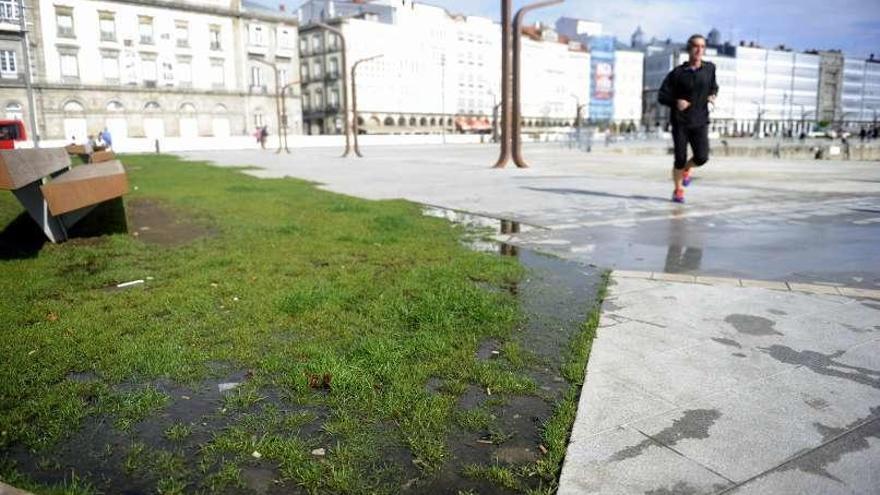 Un hombre corre por la Marina, ayer, ante el charco.