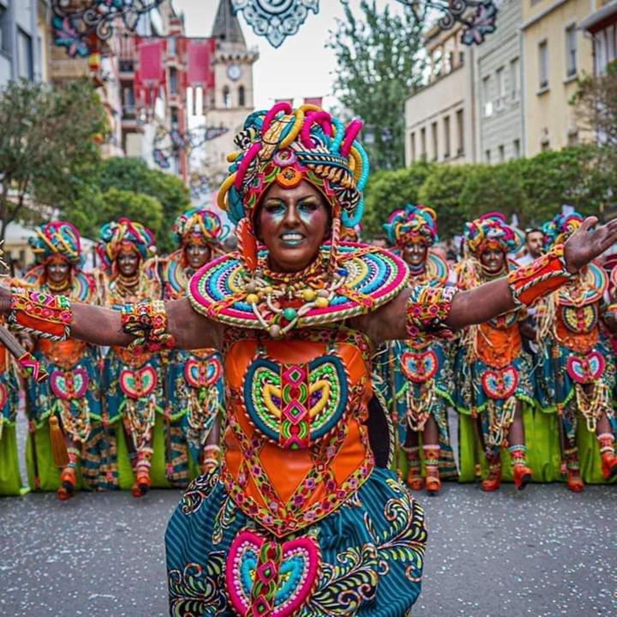 Las comparsas de Villena desfilando por las calles de la localidad, con sus coloridos vestidos, durante las fiestas del año 2019.