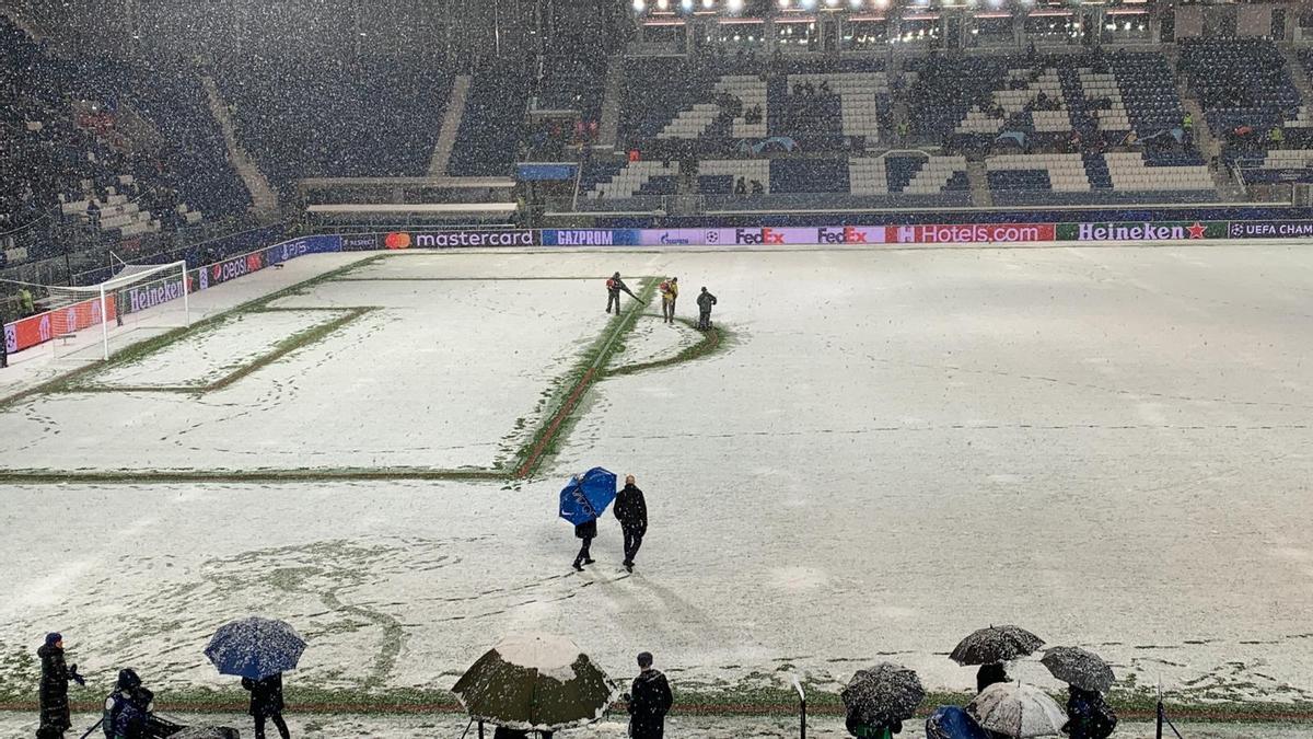 Operarios intentan que se pueda disputar el partido pese a la gran nevada.