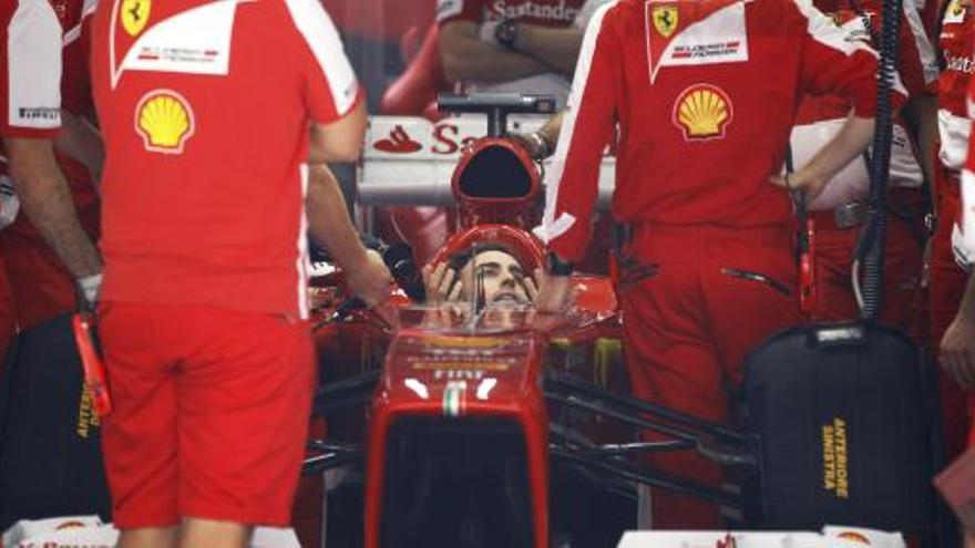 Alonso charla con sus mecánicos en boxes.