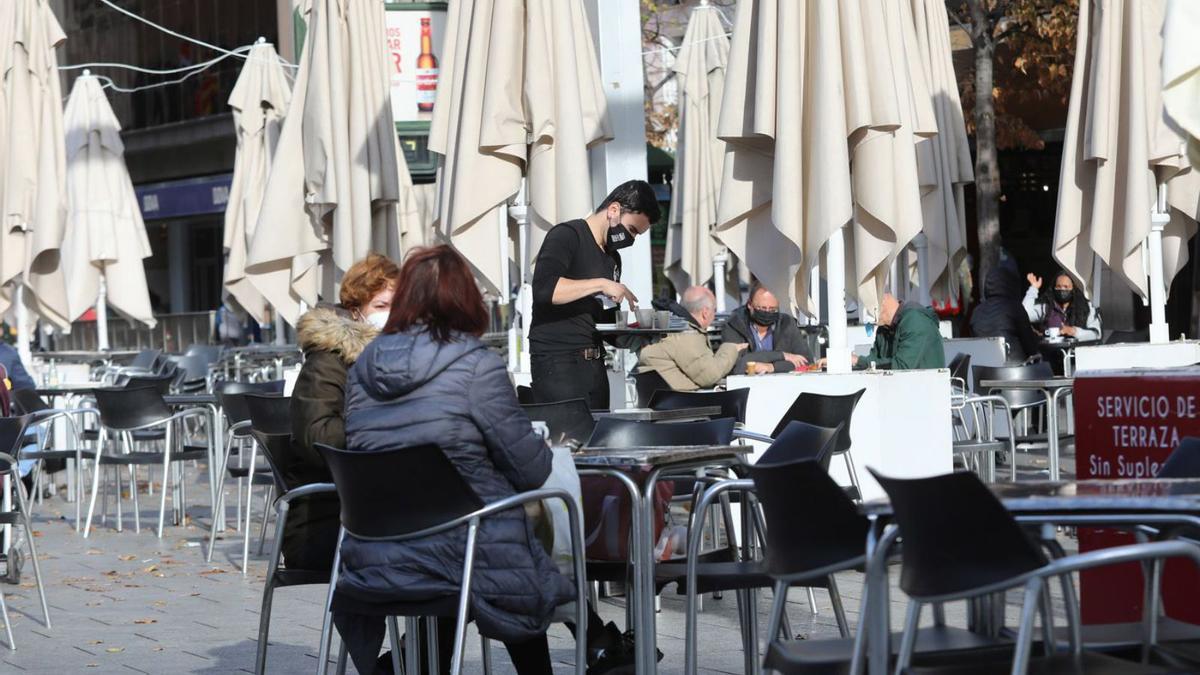 Un camarero recoge una mesa en un céntrico bar de Zaragoza, durante la pandemia.