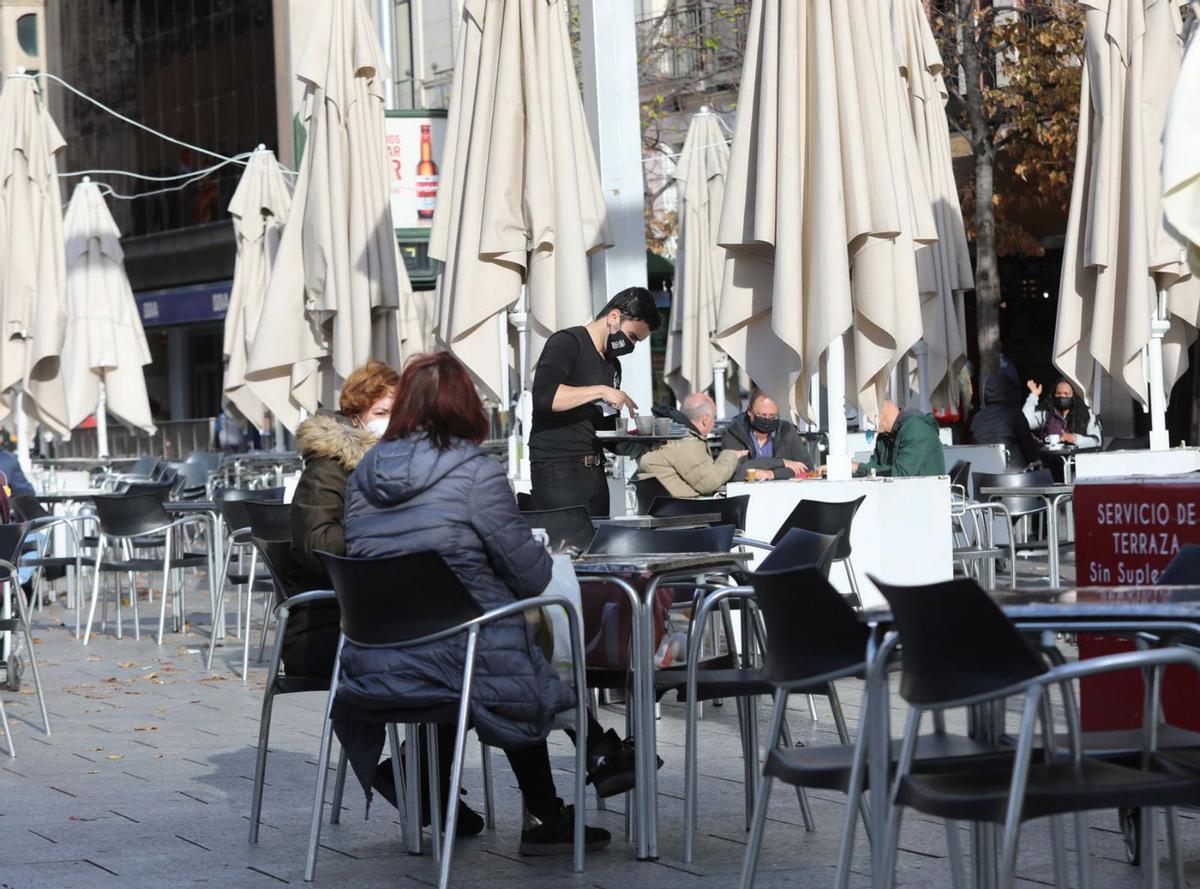 Un camarero recoge una mesa en un céntrico bar de Zaragoza, durante la pandemia.