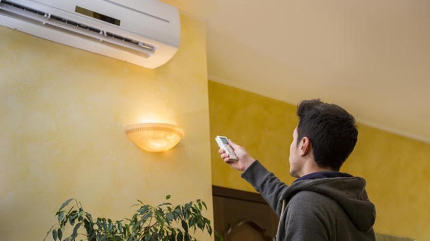 Un hombre regula la temperatura del aire acondicionado.