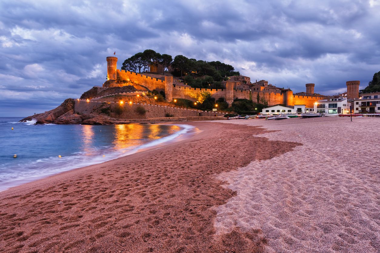 El recinto amurallado de Tossa de Mar visto desde la playa al atardecer