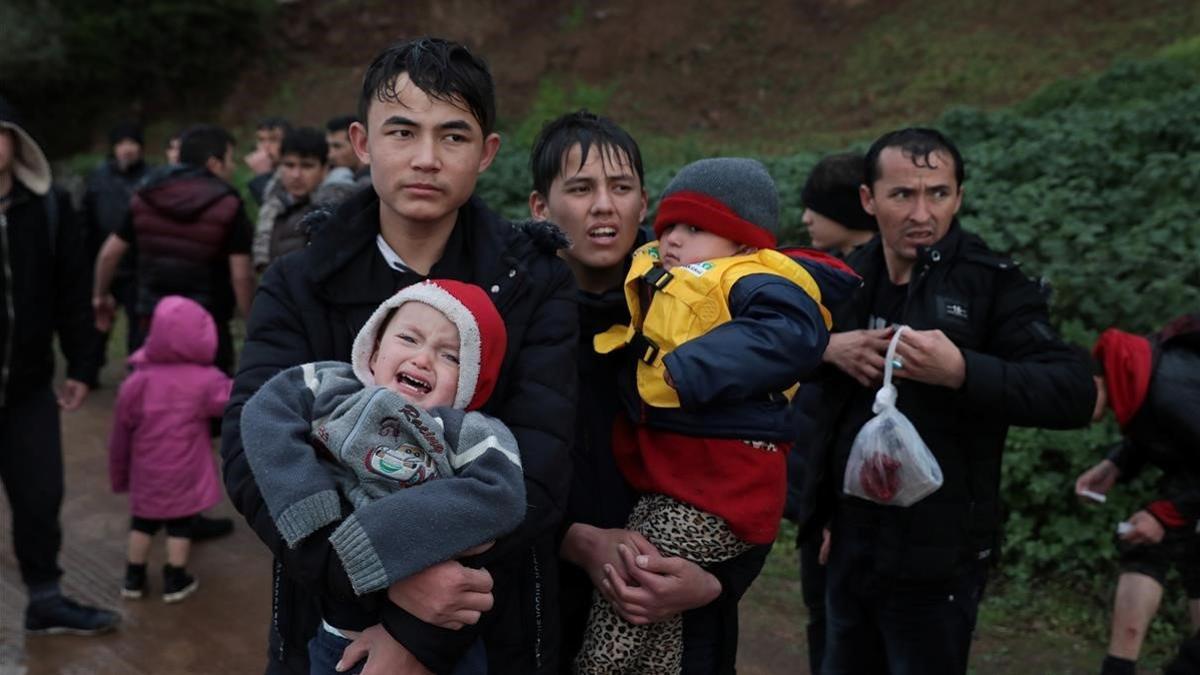 Migrantes caminan por una carretera de la isla de Lesbos tras llegar desde Turquía, este jueves.