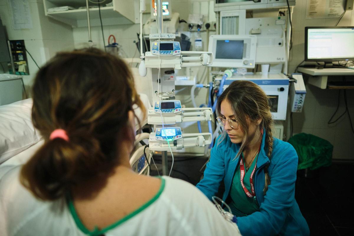 Una sanitaria del Hospital Universitario de Canarias junto a una paciente.