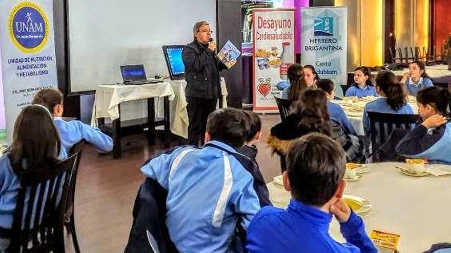 Román Álvarez, ayer, con un ejemplar del libro, ante los alumnos.