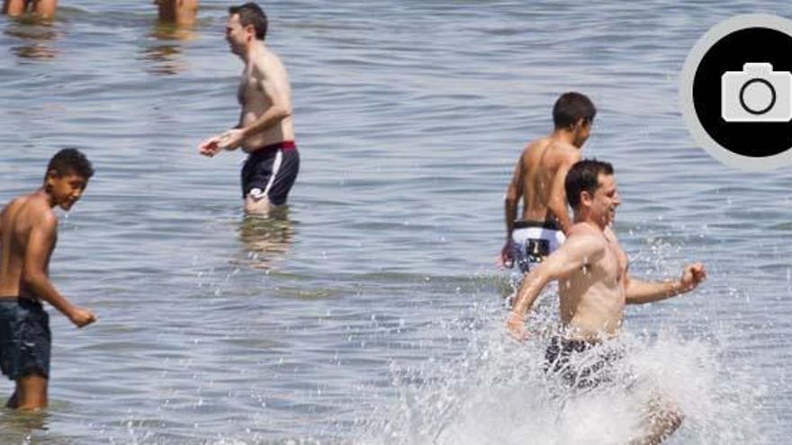 Los primeros bañistas del año prueban la temperatura de las aguas de la playa del Cabanyal.