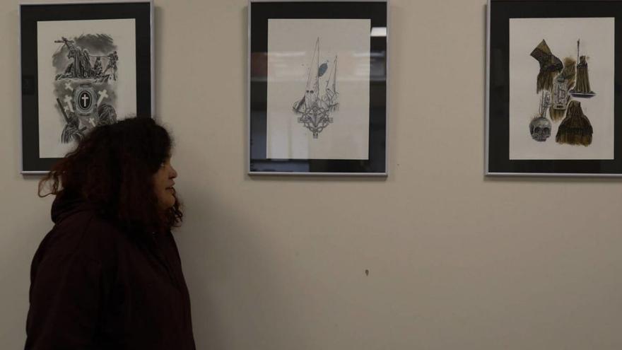 Una mujer observa las obras sobre la Semana Santa exhibidas en Peromato.